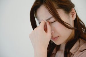 眼精疲労の辛い症状に悩む女性